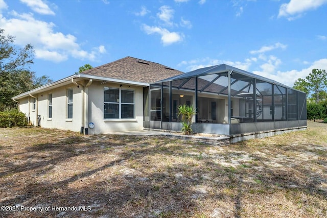 rear view of property featuring a lanai and a patio area