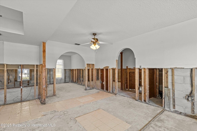 interior space with ceiling fan and a textured ceiling