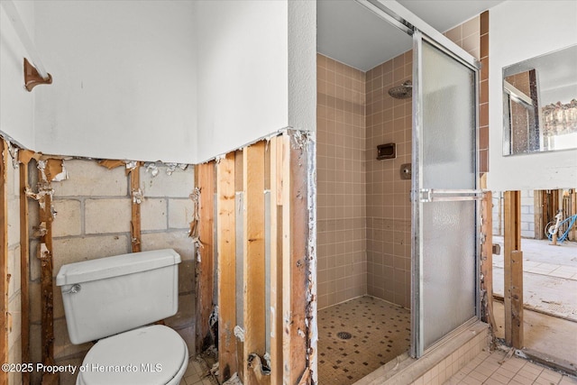 bathroom with a shower with shower door and toilet