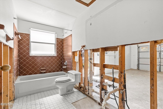 bathroom featuring tiled shower / bath combo, toilet, and tile patterned floors