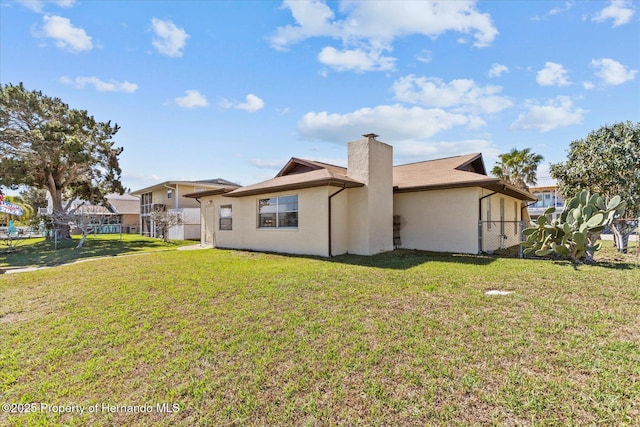 rear view of property featuring a yard