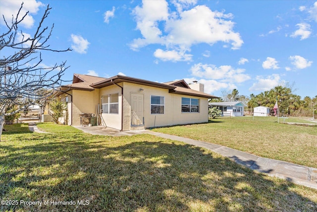 rear view of property with a lawn