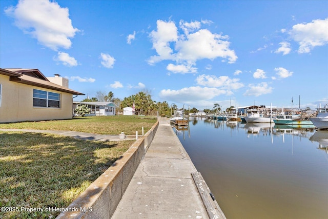 dock area with a water view and a lawn