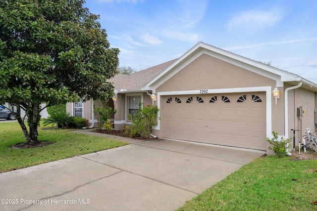 single story home featuring concrete driveway, a front lawn, an attached garage, and stucco siding