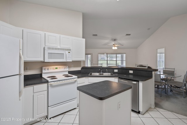 kitchen with white appliances, a sink, white cabinets, and a center island