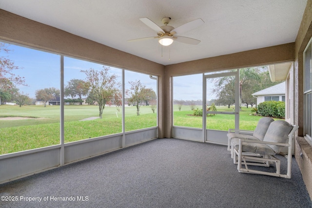 unfurnished sunroom featuring a ceiling fan