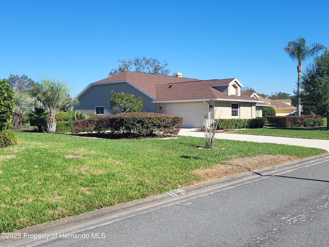 view of front facade featuring a garage, a front lawn, concrete driveway, and stucco siding