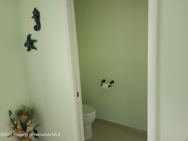 bathroom with toilet and baseboards