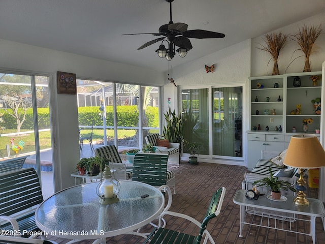 sunroom / solarium with lofted ceiling and ceiling fan