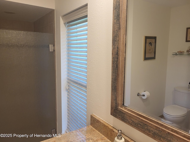 full bath featuring a stall shower and toilet