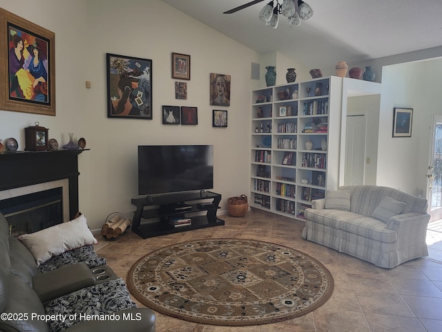 living room featuring lofted ceiling, ceiling fan, a fireplace, and light tile patterned flooring