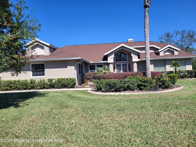 view of front of house with a front yard and stucco siding