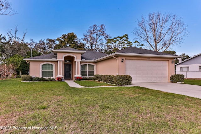 view of front of house with a garage, a front yard, driveway, and stucco siding