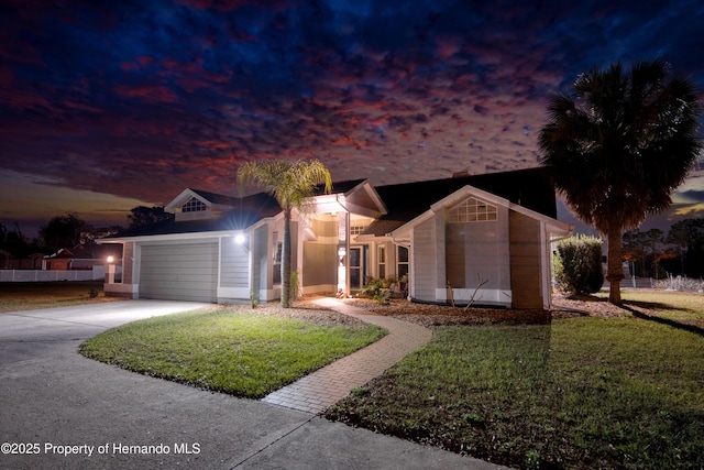 ranch-style house featuring a garage, driveway, a front lawn, and an outbuilding