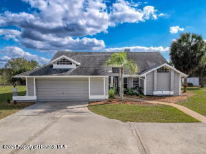 view of front of house featuring a front lawn, concrete driveway, and an attached garage