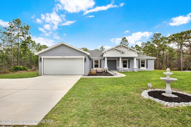 view of front of house featuring a shingled roof, a front yard, driveway, stucco siding, and a garage