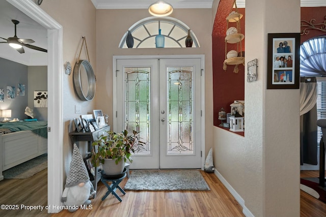 entryway featuring baseboards, ornamental molding, wood finished floors, and french doors