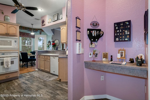 kitchen featuring a sink, white appliances, light brown cabinets, and dark wood-type flooring