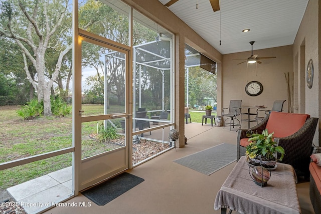 sunroom / solarium featuring a ceiling fan