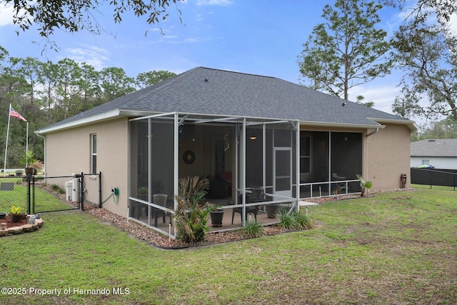 back of house featuring a sunroom, a gate, fence, and a yard