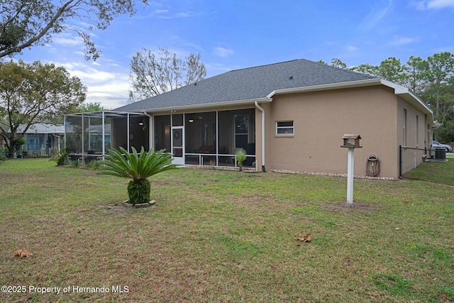 back of property with a lawn, fence, a sunroom, and stucco siding