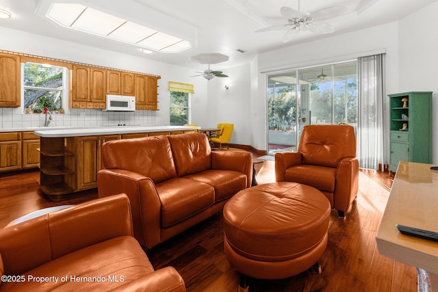 living area with dark wood-style floors and a ceiling fan