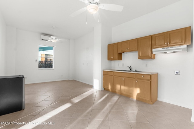 kitchen featuring brown cabinets, light countertops, a ceiling fan, a sink, and under cabinet range hood