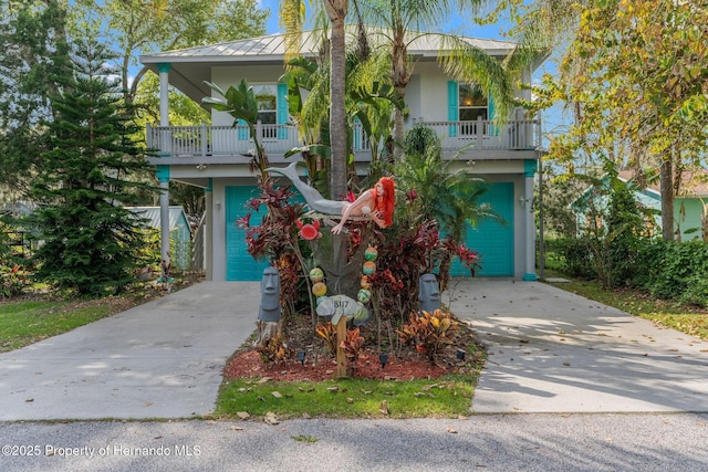 view of front of property featuring driveway, an attached garage, metal roof, and stucco siding