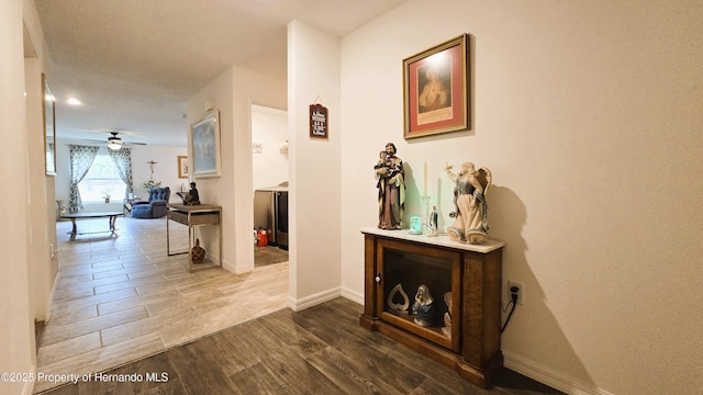 hall with baseboards and wood finished floors