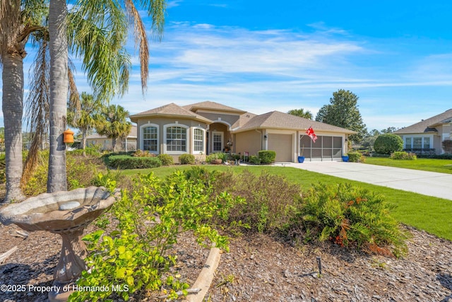 view of front of home with a garage, a front yard, driveway, and stucco siding