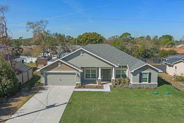 view of front of home with a shingled roof, concrete driveway, an attached garage, a front yard, and fence