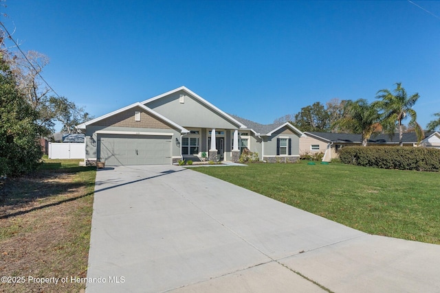 view of front of property with an attached garage, driveway, fence, and a front lawn