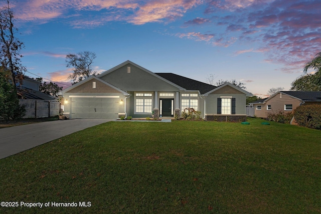 view of front facade featuring a garage, a yard, driveway, and stucco siding