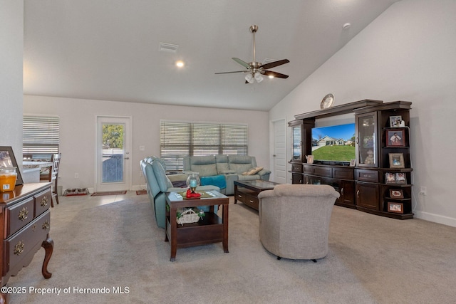 living area with vaulted ceiling, baseboards, a ceiling fan, and light colored carpet