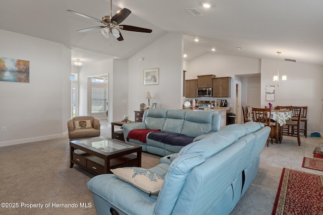 living area with ceiling fan with notable chandelier, high vaulted ceiling, visible vents, and baseboards