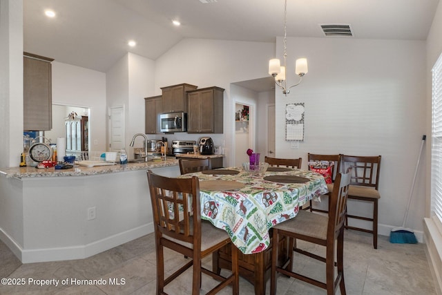 dining space with light tile patterned floors, high vaulted ceiling, visible vents, and baseboards