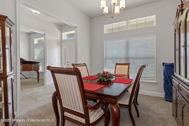 dining space featuring light tile patterned flooring, baseboards, a notable chandelier, and light colored carpet