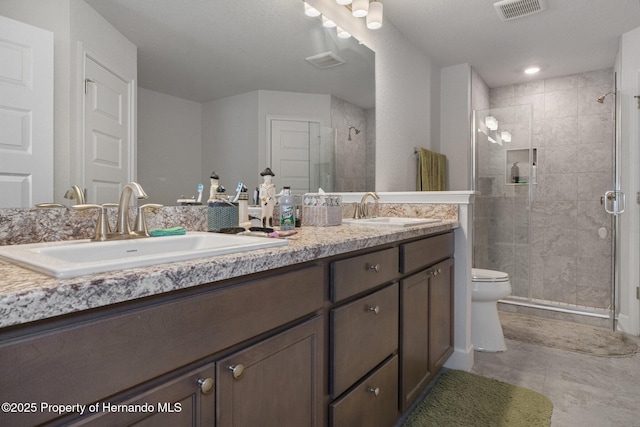 bathroom with visible vents, a sink, and double vanity