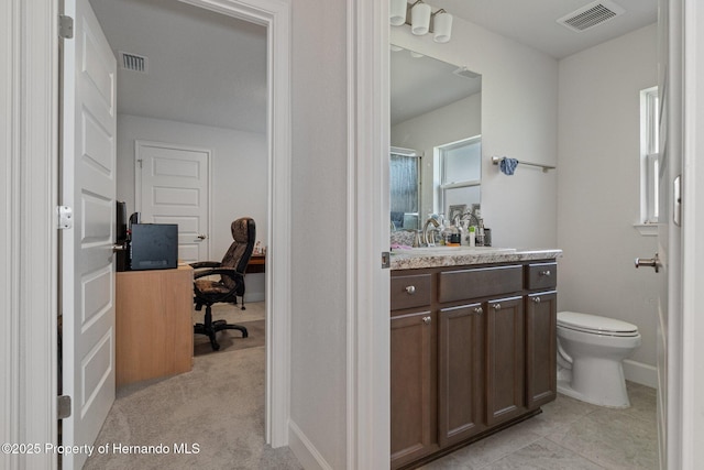 bathroom with baseboards, visible vents, vanity, and toilet