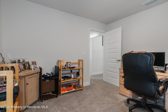 office area featuring light colored carpet, visible vents, and baseboards