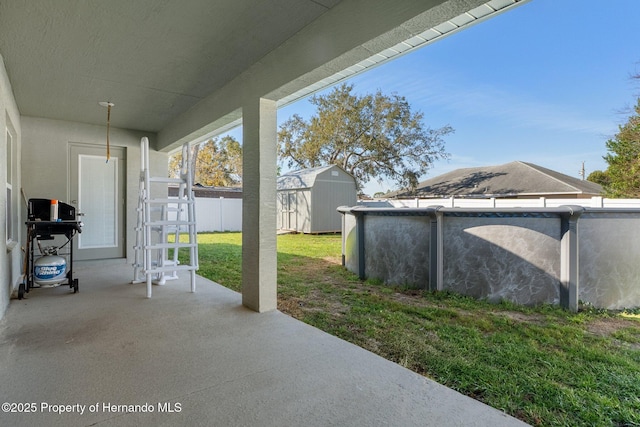 view of patio / terrace featuring a storage shed, an outdoor pool, area for grilling, fence, and an outdoor structure