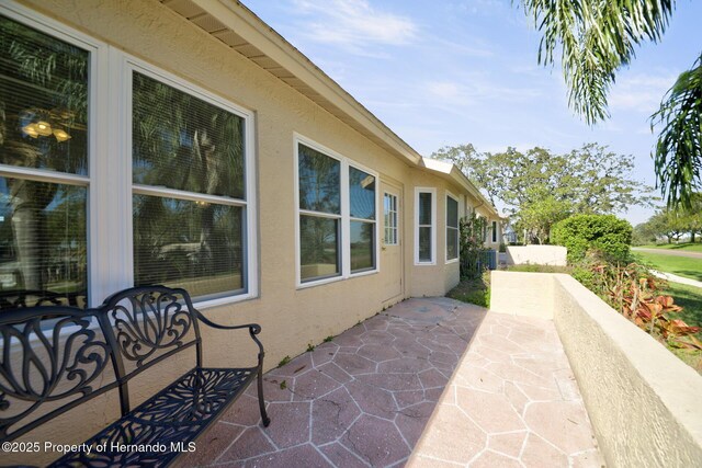 view of side of property with a patio and stucco siding