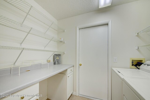 clothes washing area featuring a textured ceiling, laundry area, and washing machine and clothes dryer