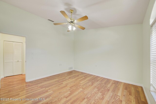 empty room featuring light wood finished floors, baseboards, and visible vents