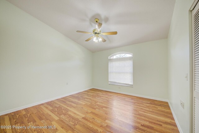 empty room featuring a ceiling fan, light wood-style flooring, and baseboards