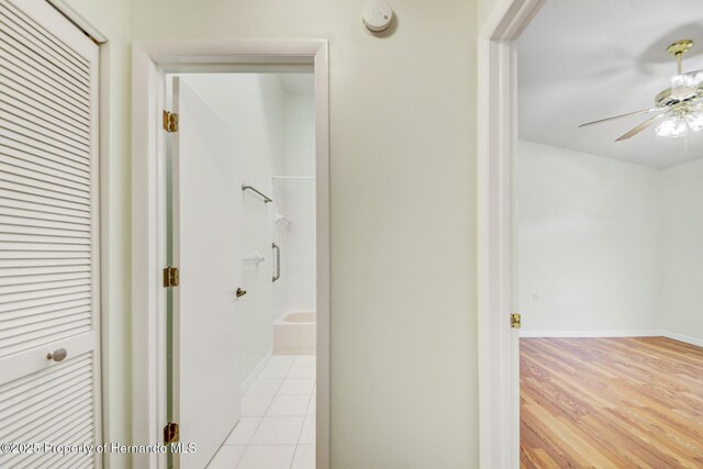 hallway featuring light wood-style flooring and baseboards