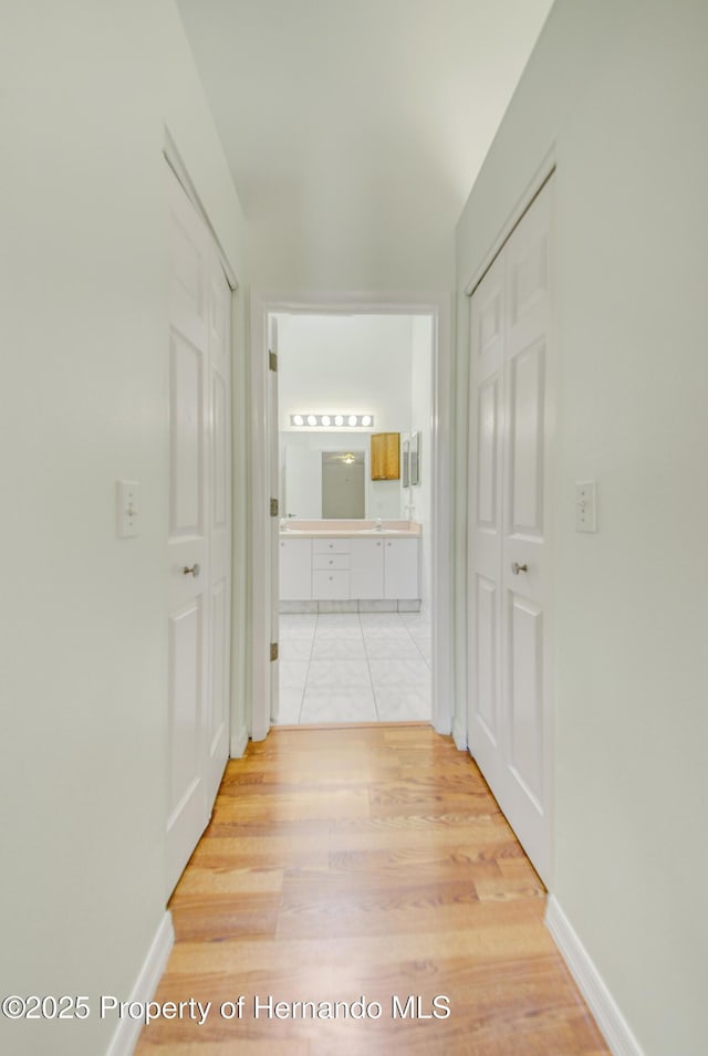 hall with light wood finished floors and baseboards