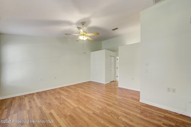 spare room with visible vents, ceiling fan, light wood-style flooring, and baseboards