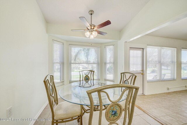 dining room with light tile patterned floors, vaulted ceiling, and a ceiling fan