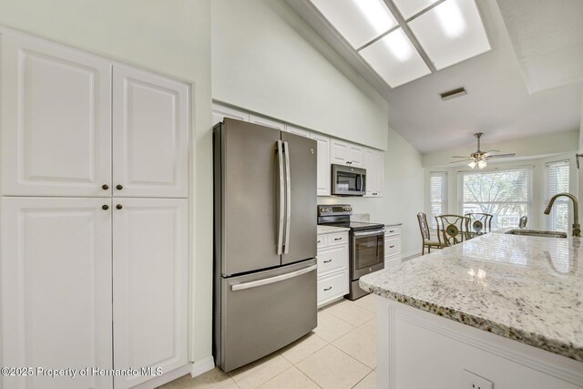 kitchen with visible vents, appliances with stainless steel finishes, white cabinets, a sink, and light stone countertops